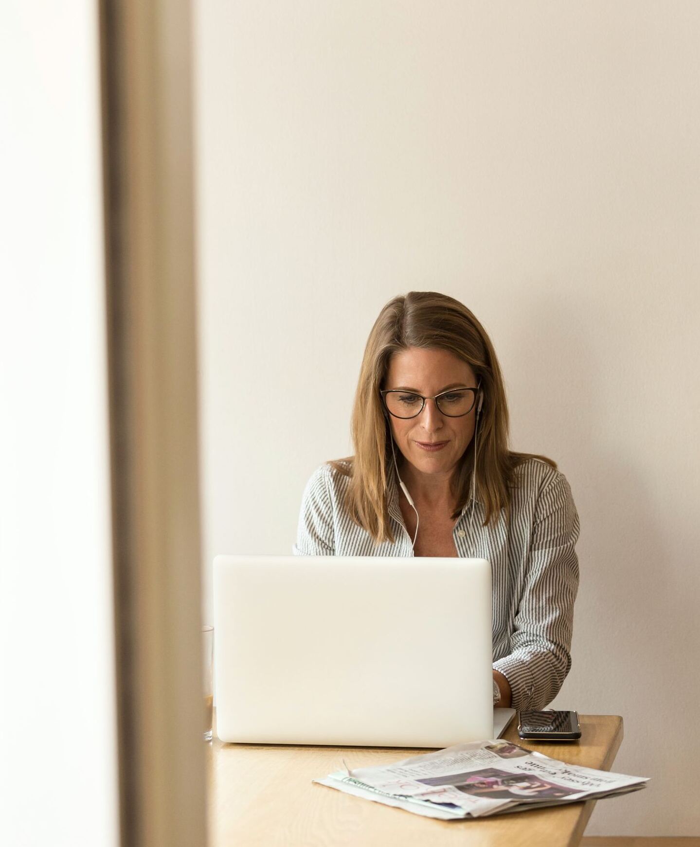 woman sitting down in front of white laptop computer